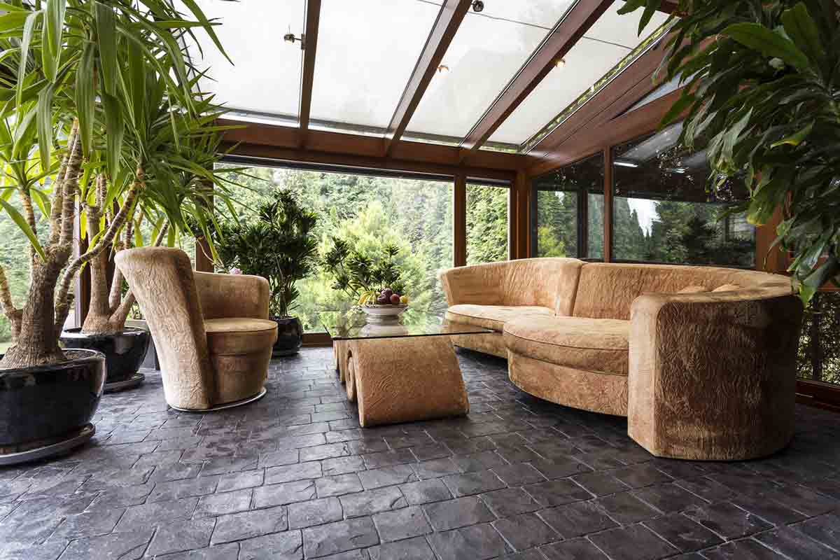 Comfortable lounge set in conservatory with natural stone granite floor
