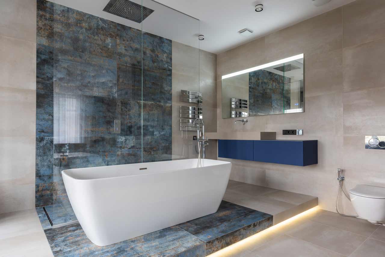 Modern bathroom with quartz countertops and granite tiles in an article that talks about the cost of countertops.