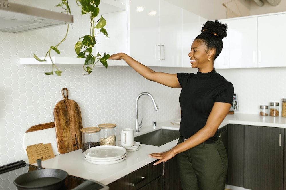 Smiling woman sliding her hands over a quartz countertop in her kitchen.